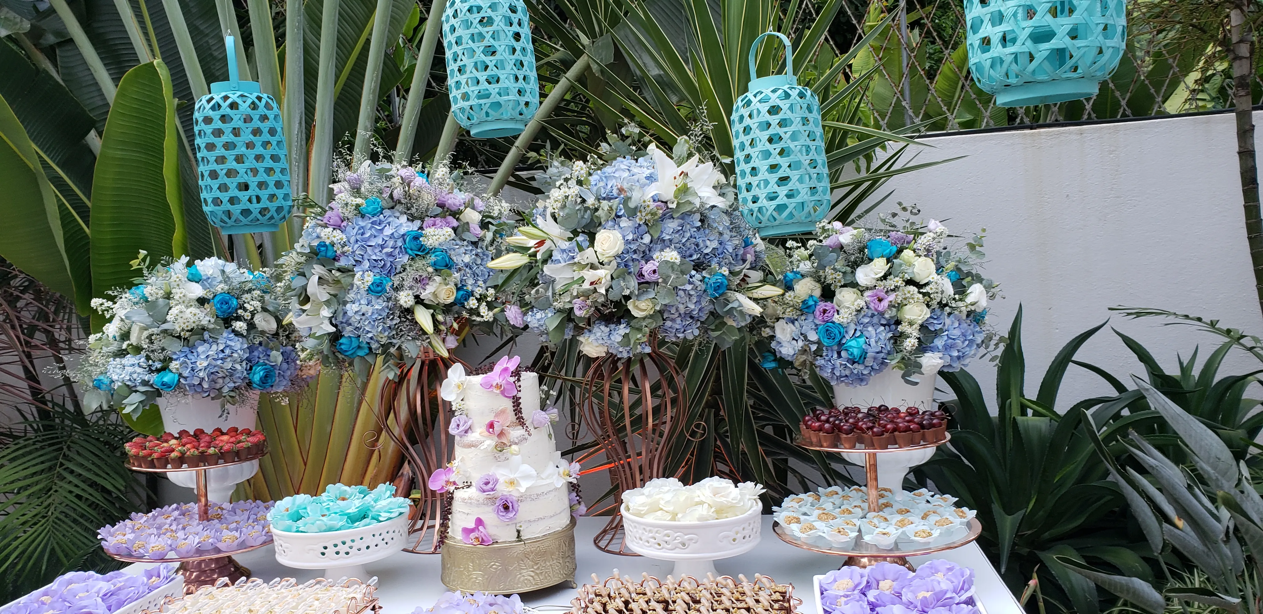 Buffet de desserts décoré d’hortensias bleus et de lanternes turquoise