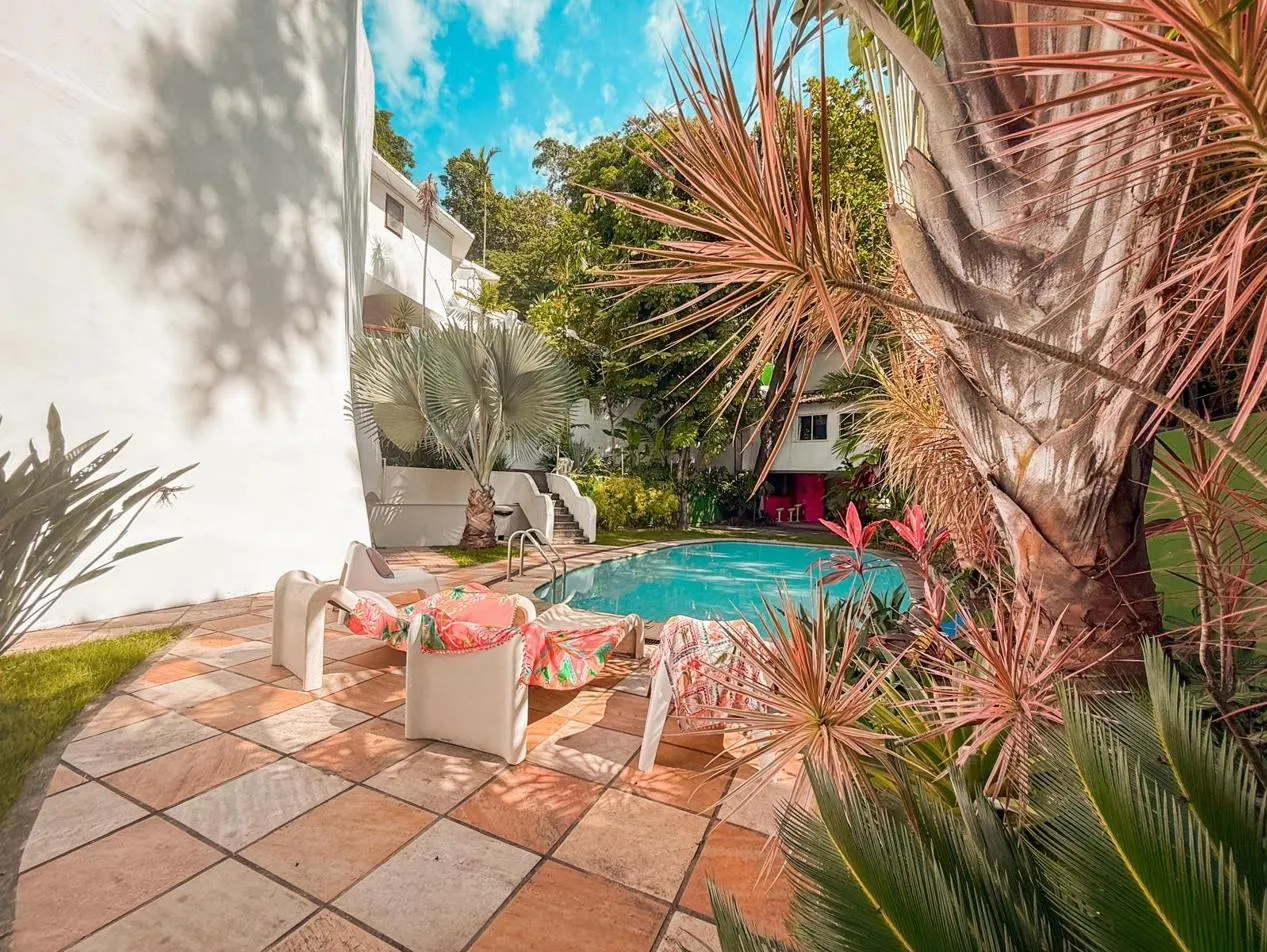 A casa modernista e a piscina cristalina no jardim tropical